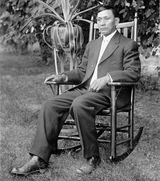 Photo of Simon Redbird, seated in a rocking chair.
